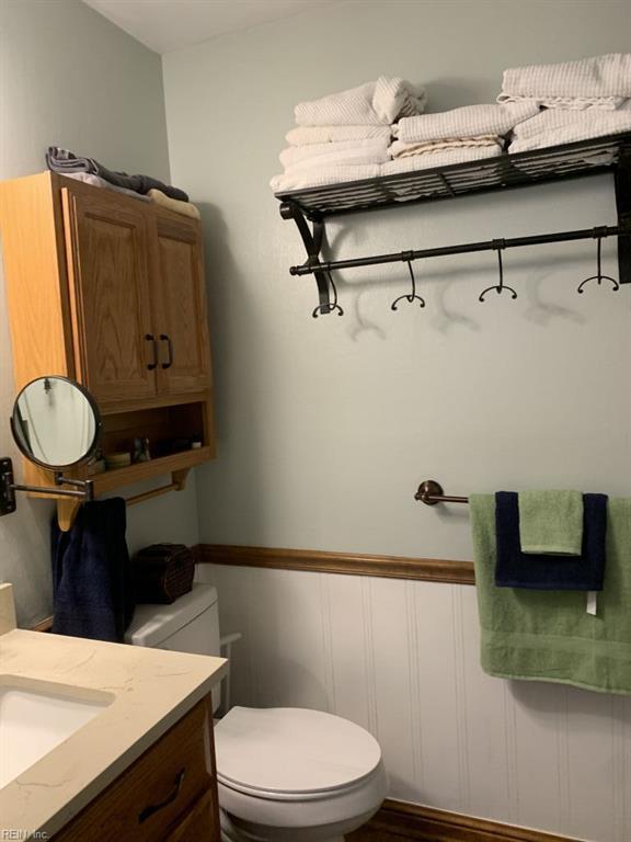 949 Kings Fork Rd, Suffolk, VA 23434 - bathroom featuring toilet, vanity, wainscoting, and wood finished floors