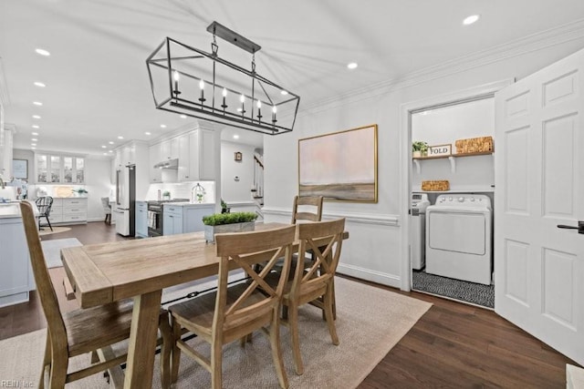 dining area featuring crown molding, washing machine and clothes dryer, recessed lighting, dark wood-type flooring, and a chandelier