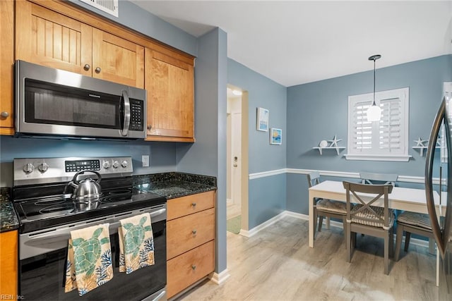 kitchen with stainless steel appliances, light wood-style flooring, pendant lighting, baseboards, and dark stone counters