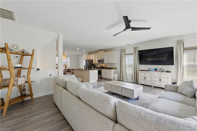 living room featuring a ceiling fan, light wood-style flooring, recessed lighting, and baseboards