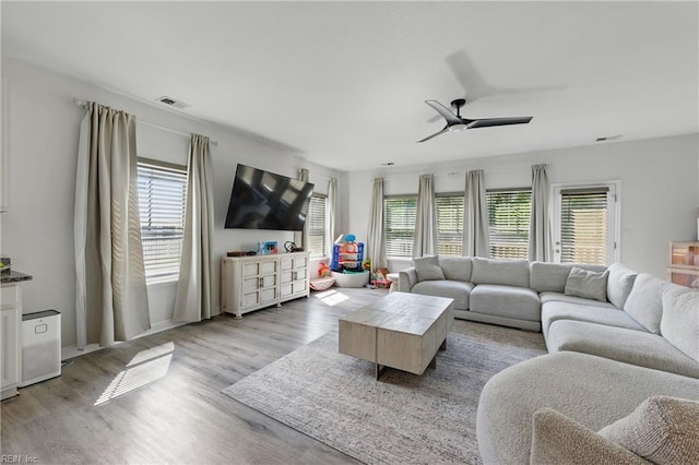 living room with a ceiling fan and light wood finished floors