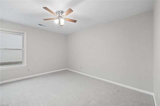 carpeted empty room with baseboards and a ceiling fan