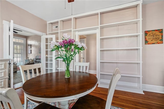 dining area featuring wood finished floors, french doors, a ceiling fan, and baseboards