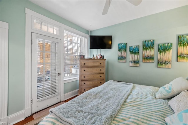 bedroom featuring baseboards, wood finished floors, access to exterior, and ceiling fan