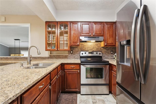 kitchen featuring stainless steel appliances, a sink, under cabinet range hood, light stone counters, and decorative backsplash