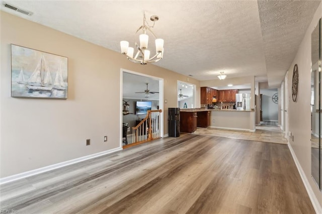 147 Fenwood Cres, Newport News, VA 23608 - unfurnished living room featuring light wood-style floors, a chandelier, a textured ceiling, and baseboards