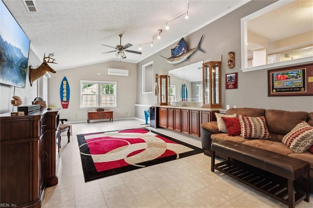 living room with a wall mounted air conditioner, ceiling fan, lofted ceiling, rail lighting, and baseboards
