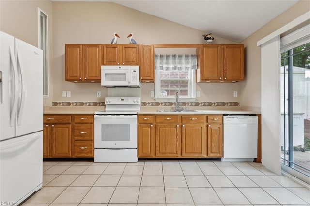 kitchen with white appliances, a sink, light countertops, lofted ceiling, and brown cabinetry