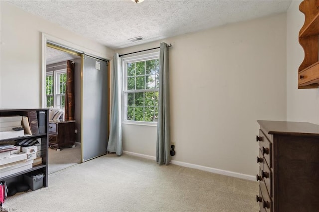 bedroom with light carpet, a closet, baseboards, and a textured ceiling