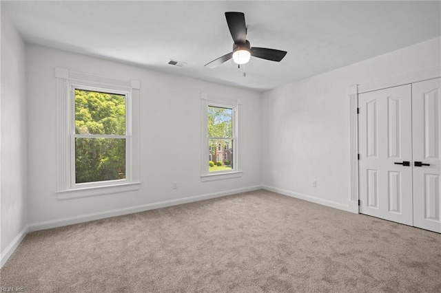 unfurnished bedroom featuring carpet floors, baseboards, a closet, and ceiling fan