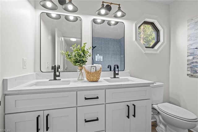 full bath featuring toilet and double vanity