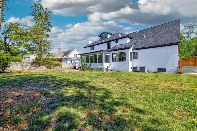 rear view of house with a sunroom and a shingled roof