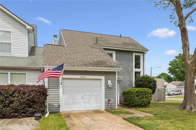 view of front of home featuring concrete driveway, roof with shingles, a front lawn, and an attached garage