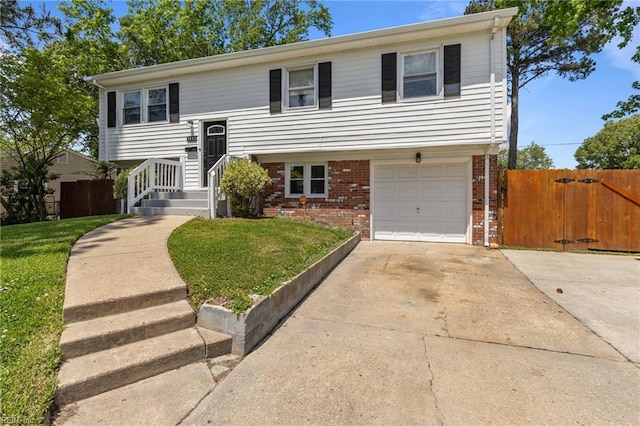 split foyer home with brick siding, a garage, and driveway