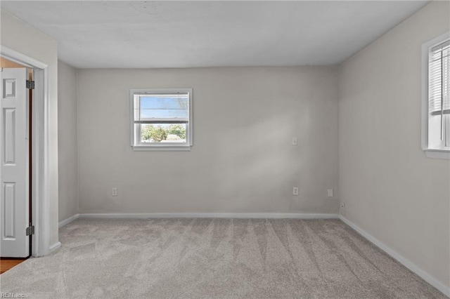 carpeted empty room featuring baseboards