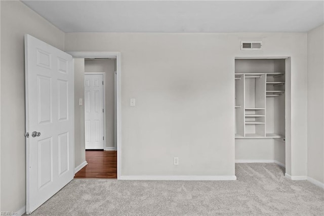 unfurnished bedroom featuring carpet floors, baseboards, and a closet