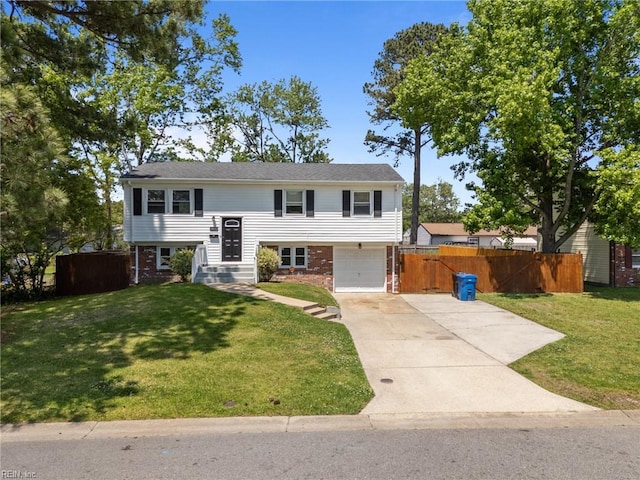 raised ranch featuring driveway, an attached garage, and brick siding