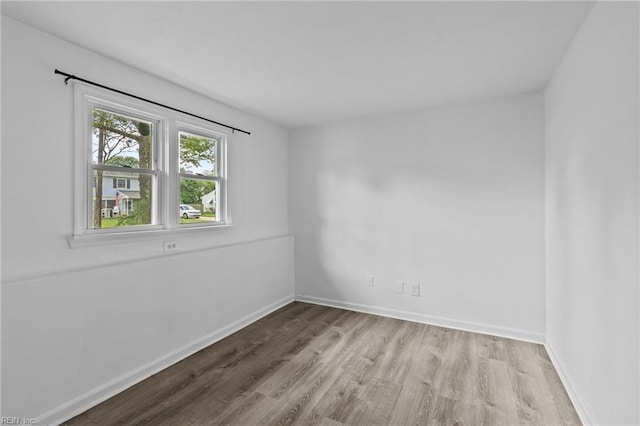unfurnished room featuring wood finished floors and baseboards