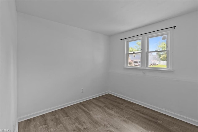 empty room featuring wood finished floors and baseboards