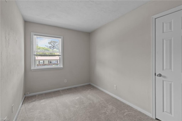 empty room featuring carpet flooring and baseboards