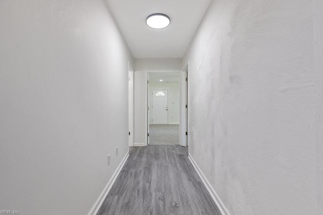 hall featuring wood finished floors and baseboards
