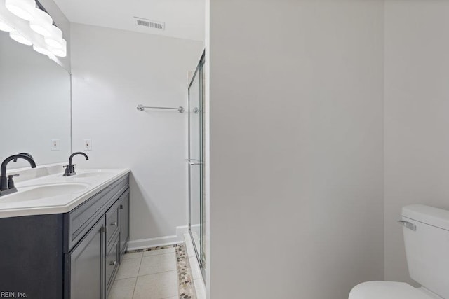 bathroom with toilet, a stall shower, double vanity, tile patterned flooring, and baseboards
