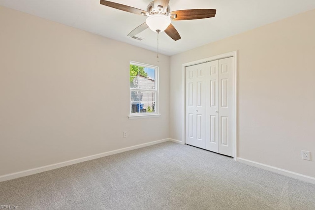 unfurnished bedroom featuring light carpet, baseboards, a closet, and ceiling fan