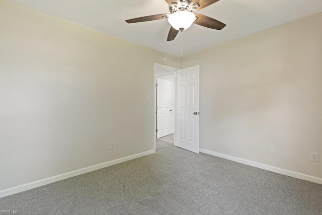 carpeted spare room with baseboards and ceiling fan