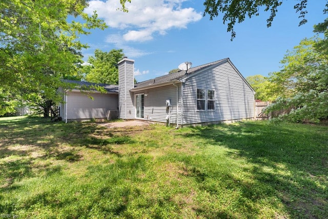back of property with a yard and a chimney
