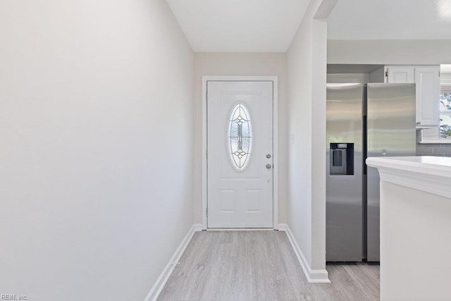 entryway featuring light wood-style flooring, plenty of natural light, and baseboards