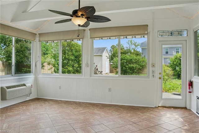 unfurnished sunroom with a ceiling fan and a wall mounted air conditioner