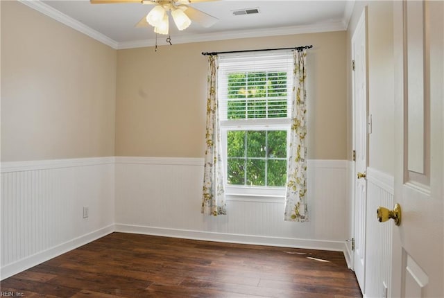 unfurnished room featuring dark wood finished floors, wainscoting, ceiling fan, and ornamental molding