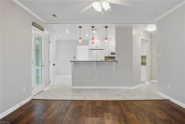 unfurnished living room with a ceiling fan, light wood-style floors, crown molding, baseboards, and recessed lighting