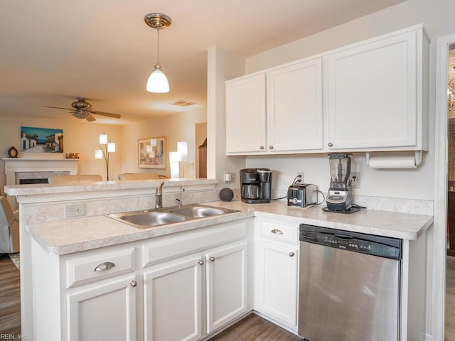 kitchen featuring dishwasher, a sink, a peninsula, ceiling fan, and white cabinetry