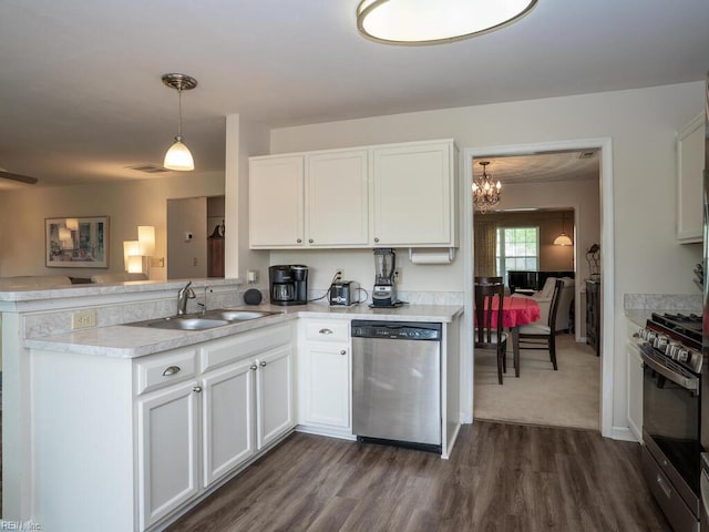kitchen with appliances with stainless steel finishes, a sink, a chandelier, a peninsula, and light countertops