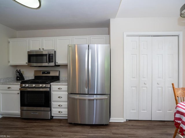 kitchen featuring appliances with stainless steel finishes, white cabinets, and dark wood-type flooring