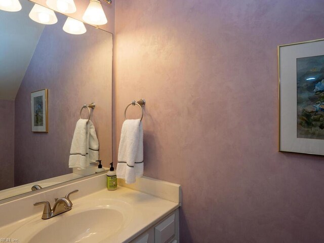 bathroom featuring vanity and lofted ceiling