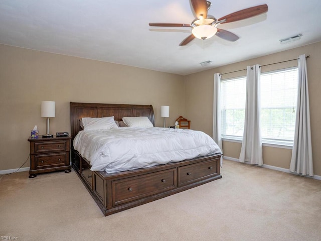 bedroom with light colored carpet, baseboards, and a ceiling fan