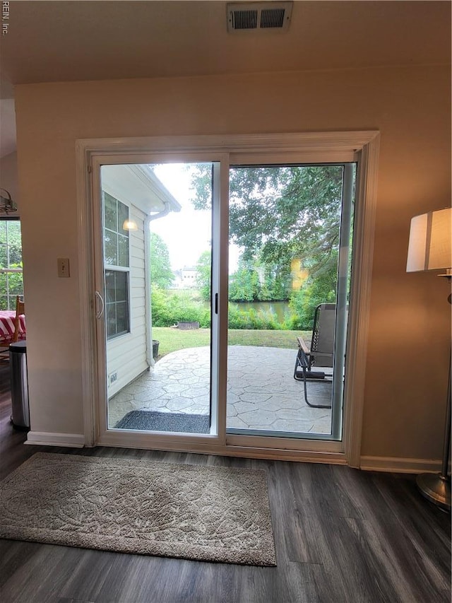 doorway with wood finished floors and baseboards