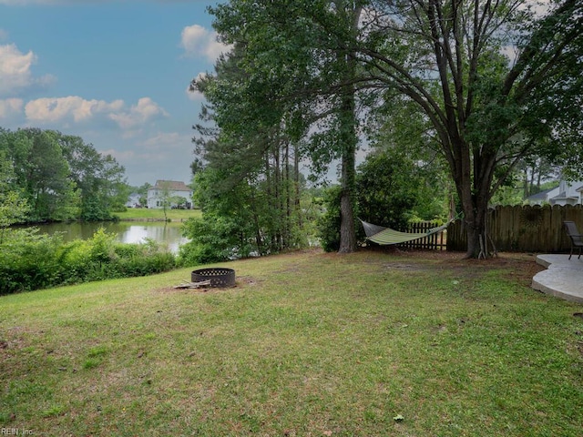 view of yard with an outdoor fire pit and a water view