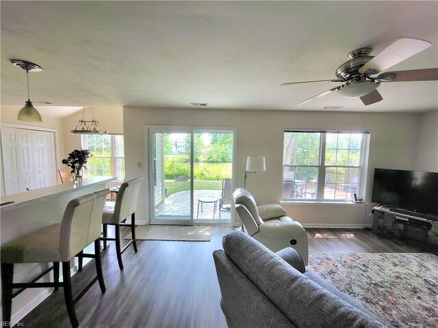 living area with baseboards, wood finished floors, and ceiling fan