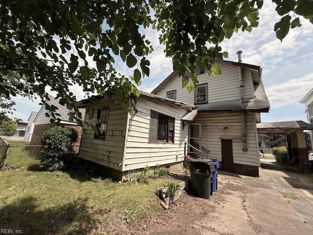 rear view of house featuring fence and crawl space