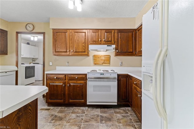 kitchen featuring white appliances, under cabinet range hood, light countertops, washer and clothes dryer, and a textured ceiling