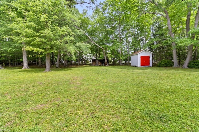 view of grassy yard featuring a storage unit and an outdoor structure