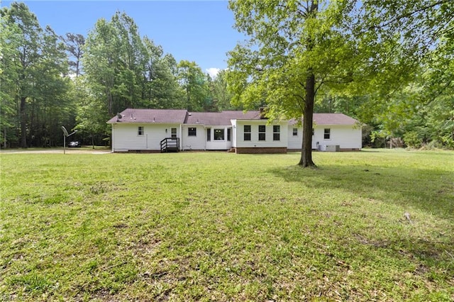 rear view of house with a lawn and crawl space