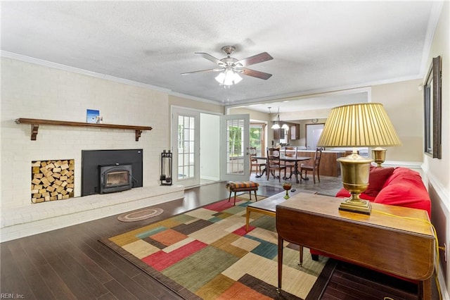 living room with wood finished floors, crown molding, ceiling fan, and a textured ceiling