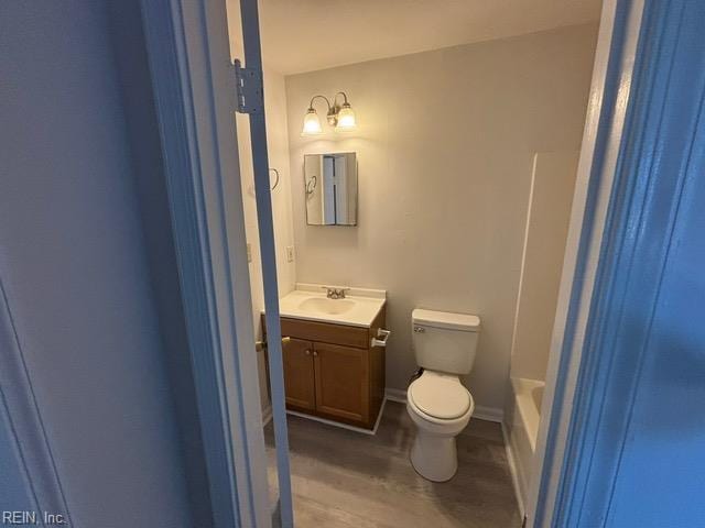 full bath featuring toilet, wood finished floors, and vanity