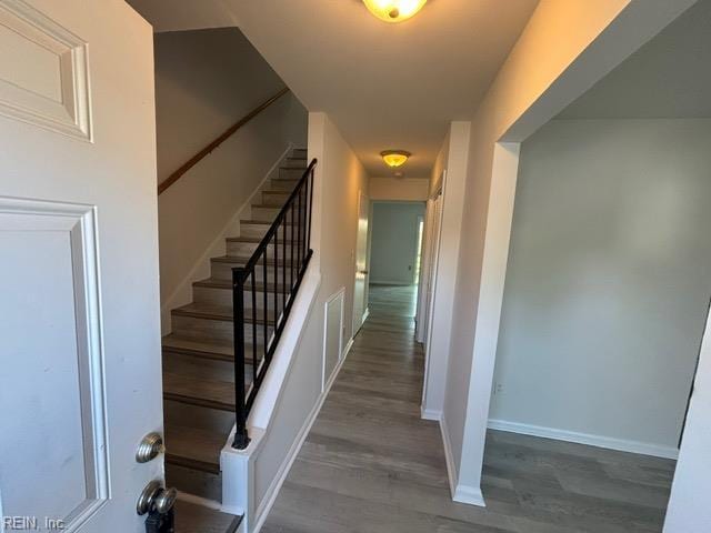 stairway with wood finished floors and baseboards