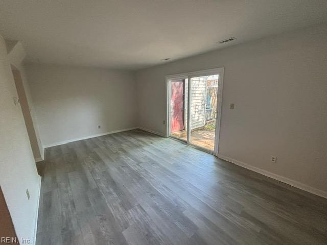 spare room featuring wood finished floors and baseboards