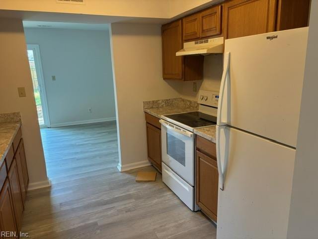 kitchen with white appliances, under cabinet range hood, brown cabinetry, light wood-style flooring, and baseboards